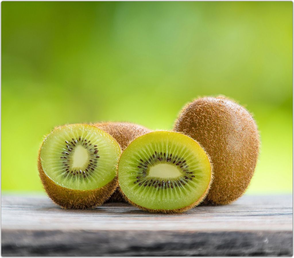 Spritzschutz Herdabdeckplatte Schneidebrett aus Glas Kiwis auf Tisch 1-Teilig (60x52cm)