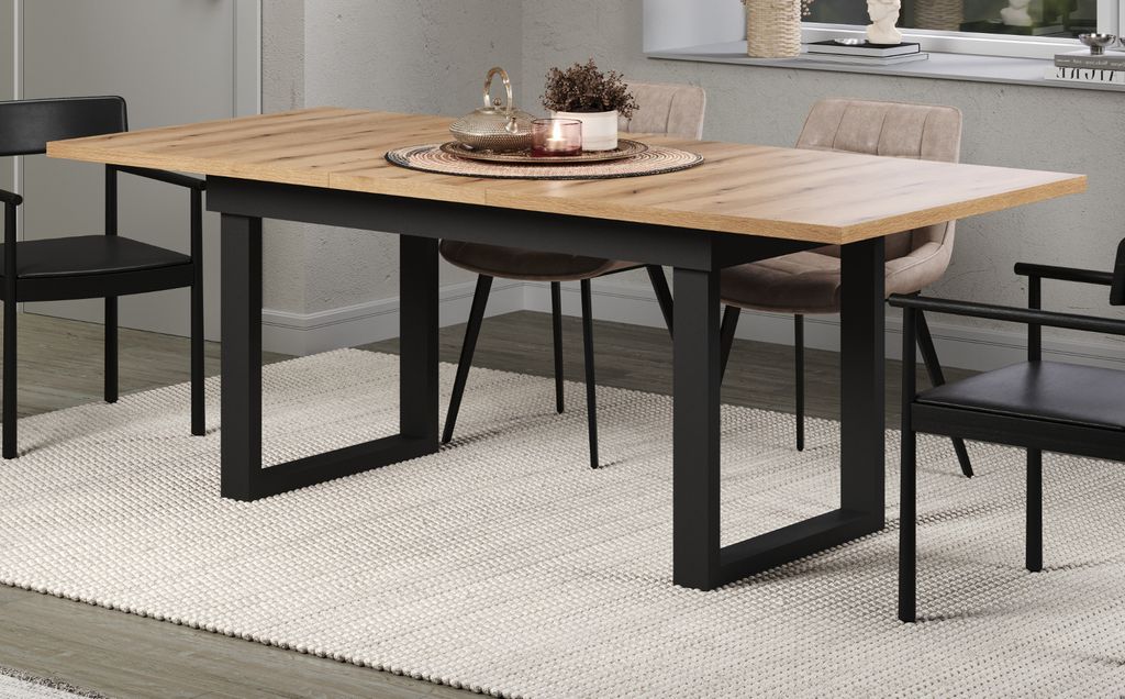 A dining table set in a dining room with chairs and a rug.