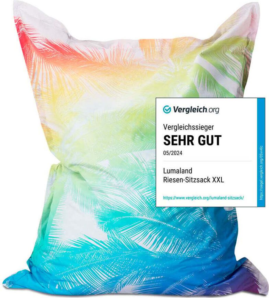 A large beanbag chair with a tropical palm print in rainbow colors, featuring a review badge from Vergleich.org.
