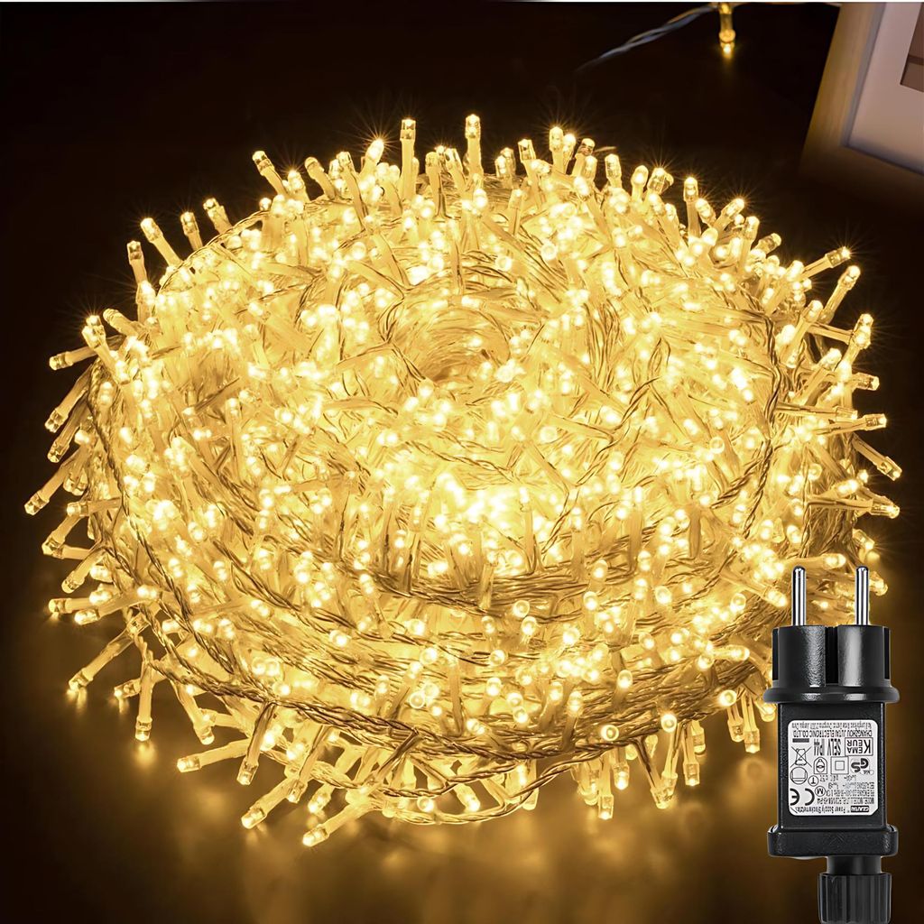 A large coil of warm white LED string lights with a black power adapter in the foreground.