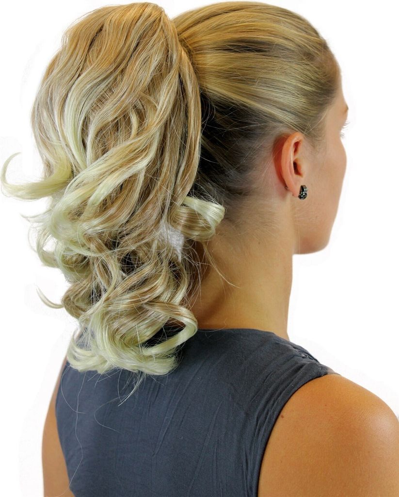 A woman's head and shoulders are shown from the side, wearing a hairpiece.
