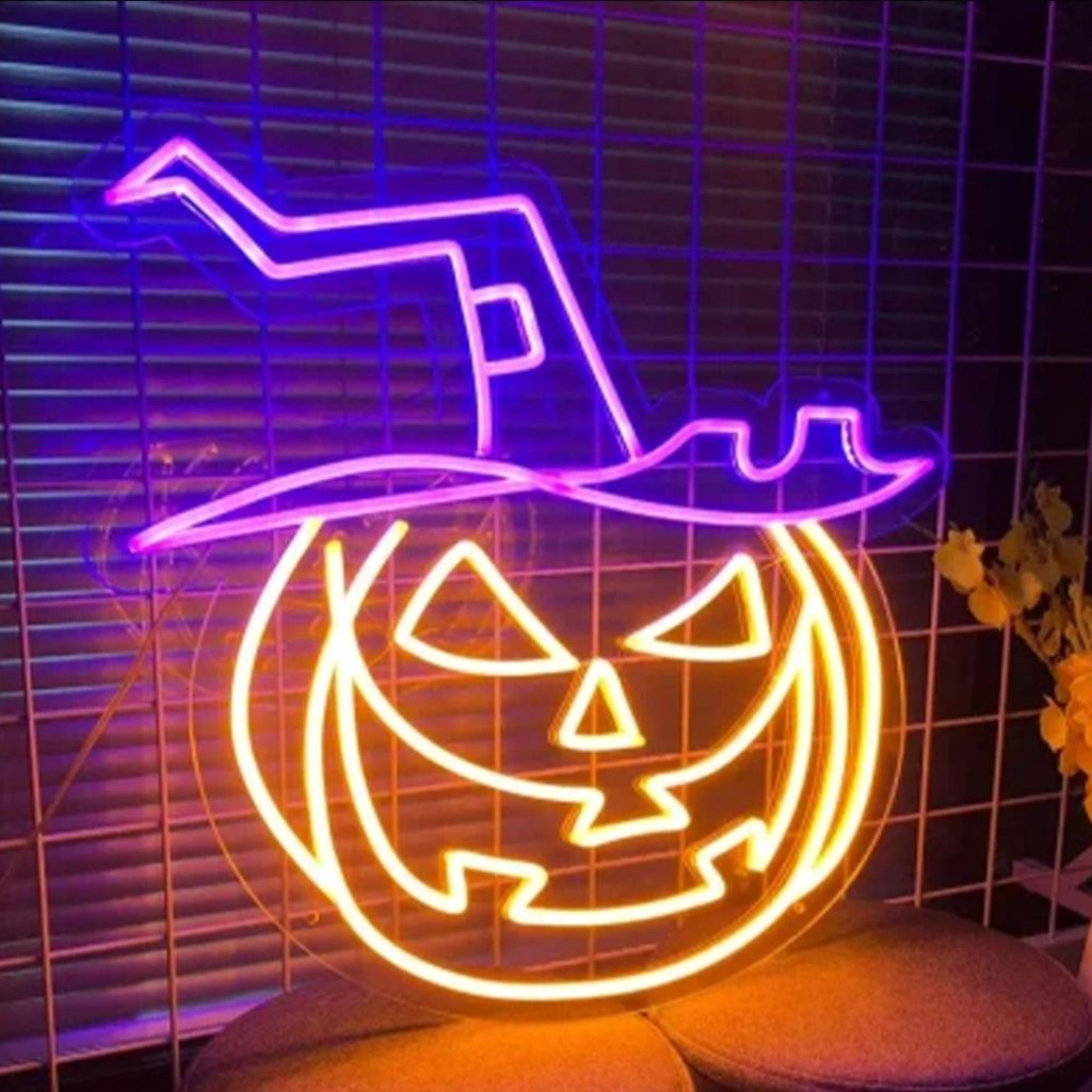 A neon sign of a jack-o'-lantern wearing a witch's hat, displayed indoors.