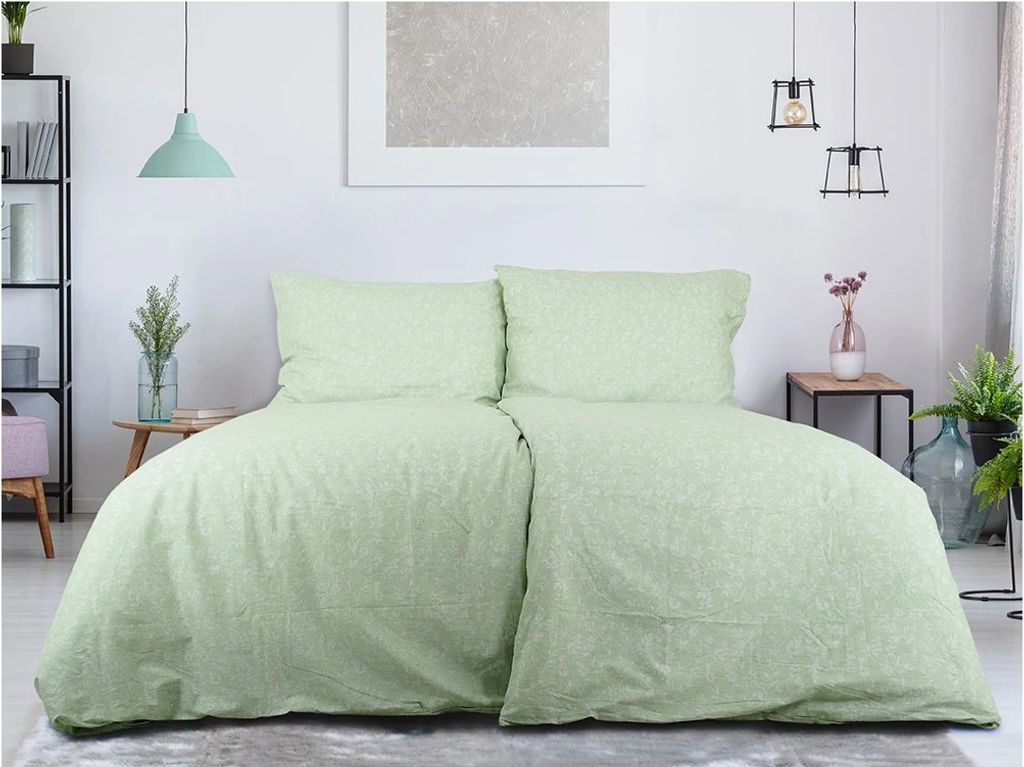 A bedroom scene with a bed made with green floral patterned bedding.