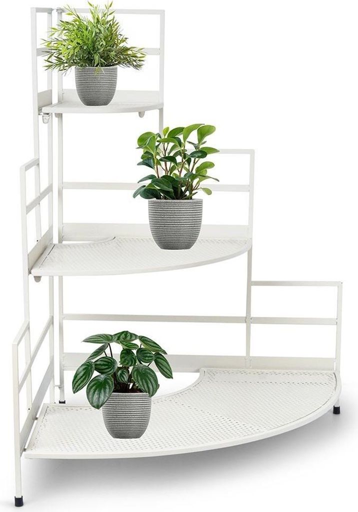 A white metal corner shelf with three tiers, holding three potted plants.