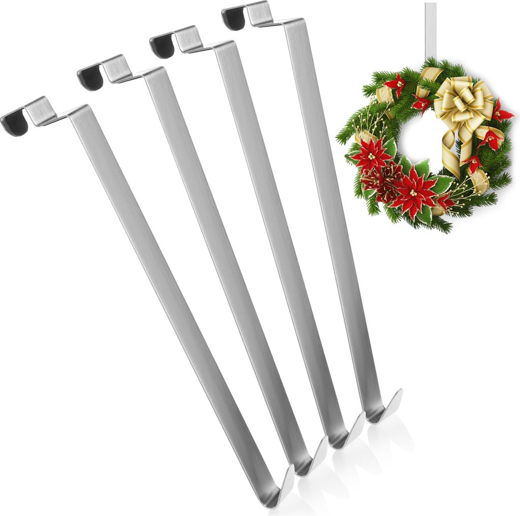 Four silver metal stocking holders arranged diagonally, with a Christmas wreath hanging in the background.