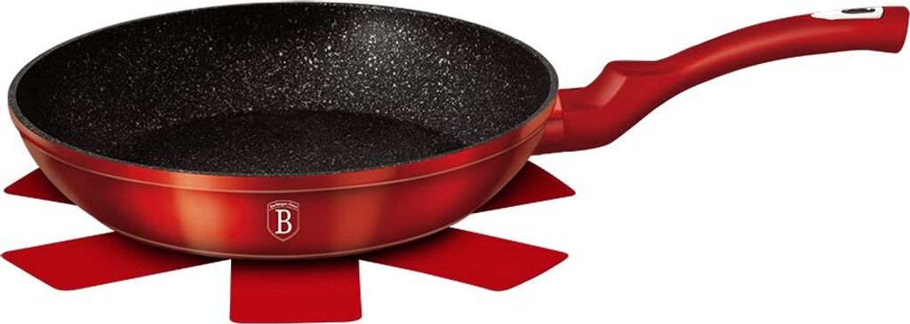 A red Berlinger Haus granitpfanne (granite pan) with a black speckled interior, placed on a red heat-resistant mat.
