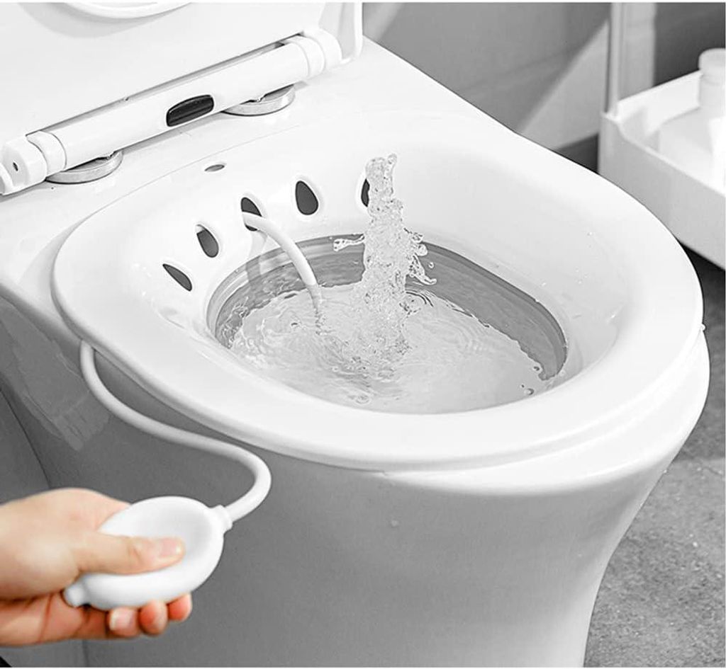 A hand is shown squeezing a bulb to operate a bidet attachment on a toilet.