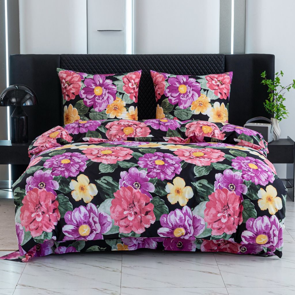 A bed with a floral patterned duvet and pillows.