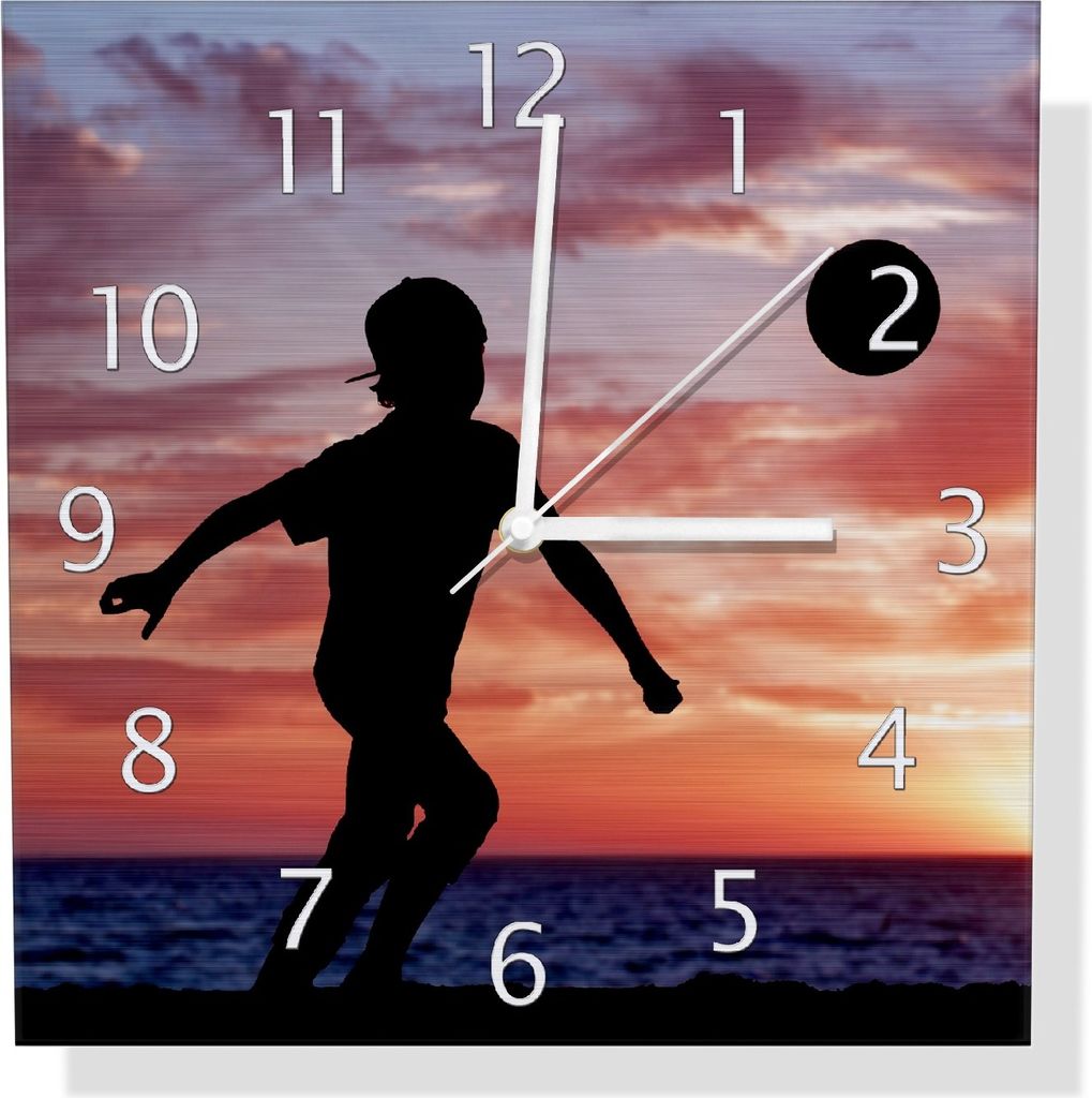 Wallario Design Wanduhr Fußball - Kleiner Junge spielt im Abendrot aus Aluverbund, Größe 30 x 30 cm