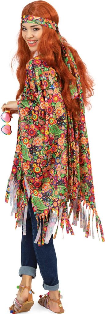 Frau im bunten Hippie-Poncho mit Stirnband; Blick über die Schulter, Fransen, Jeans und Sandalen.