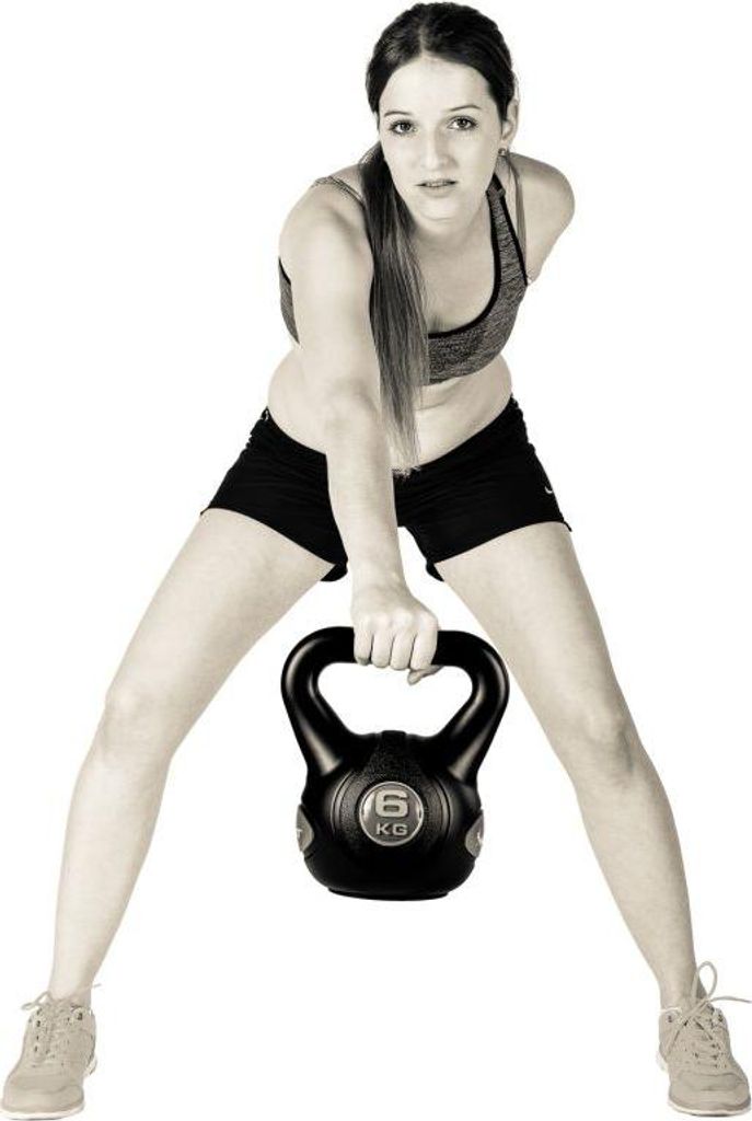 A woman is holding a kettlebell.