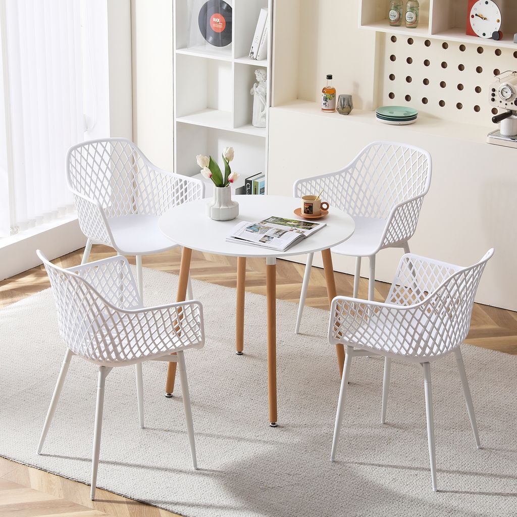 A set of four white chairs arranged around a round white table in a well-lit room.