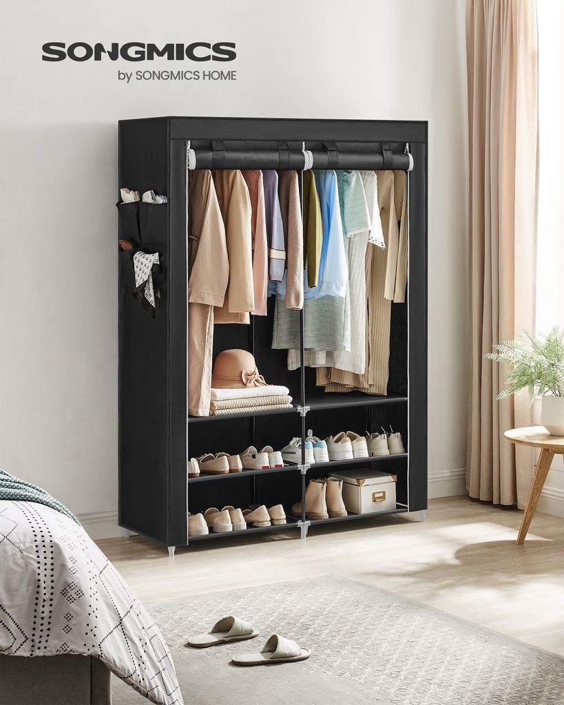 A black fabric wardrobe with clothes and shoes inside, placed in a bedroom setting.