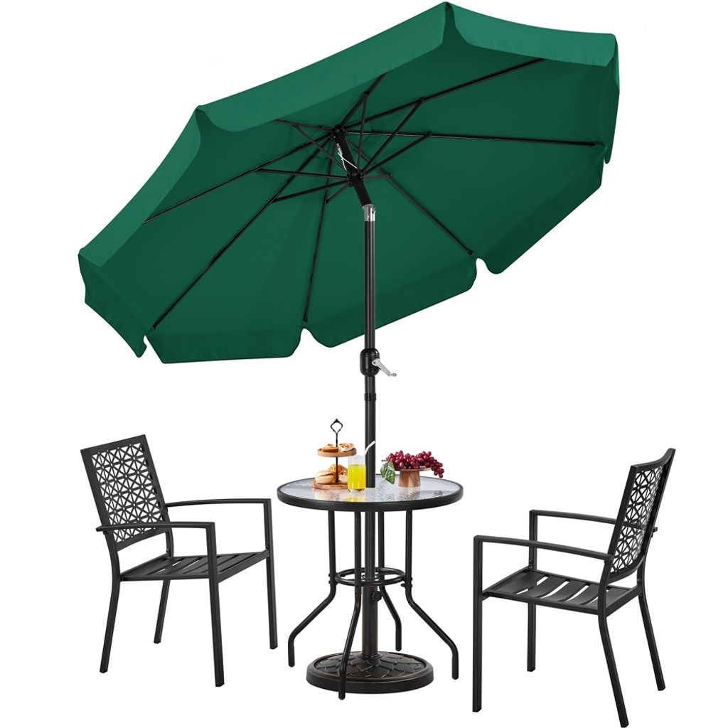 A dark green patio umbrella with a round glass-topped table and two black chairs.