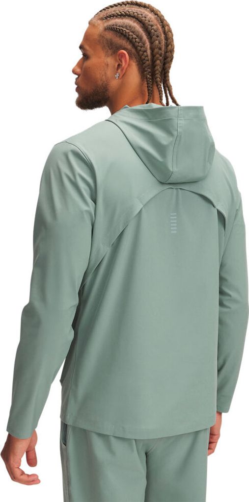 A man wearing a green hooded jacket and pants, viewed from the back.