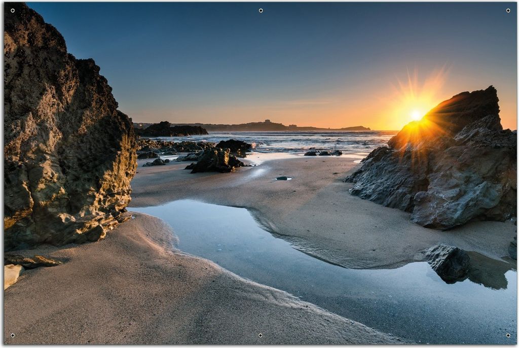Wallario Outdoor-Poster für Garten oder Balkon, Motiv Sonnenuntergang hinter einem Felsen am Strand, in ca. 61 x 91,50 cm