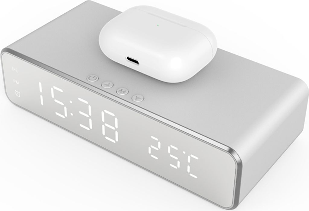 A silver digital alarm clock with a white wireless charging case on top, displaying the time and temperature.