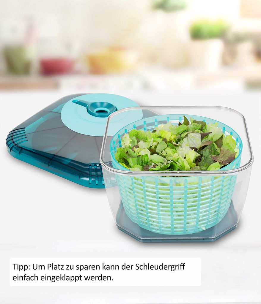 A salad spinner with chopped lettuce inside, shown with its lid next to it. The background is blurred.