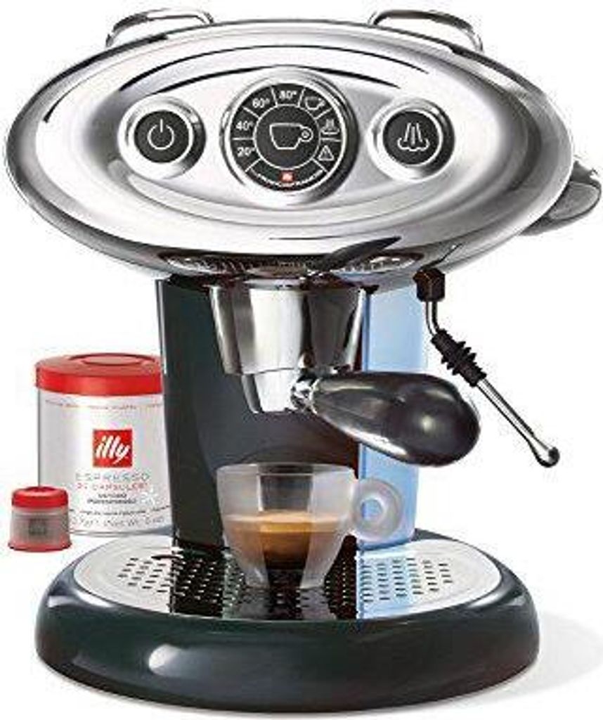 A black and silver Illy X7.1 Espressomaschine Hyperespresso Automatik is shown with a cup of espresso, a can of Illy coffee, and two small red caps.