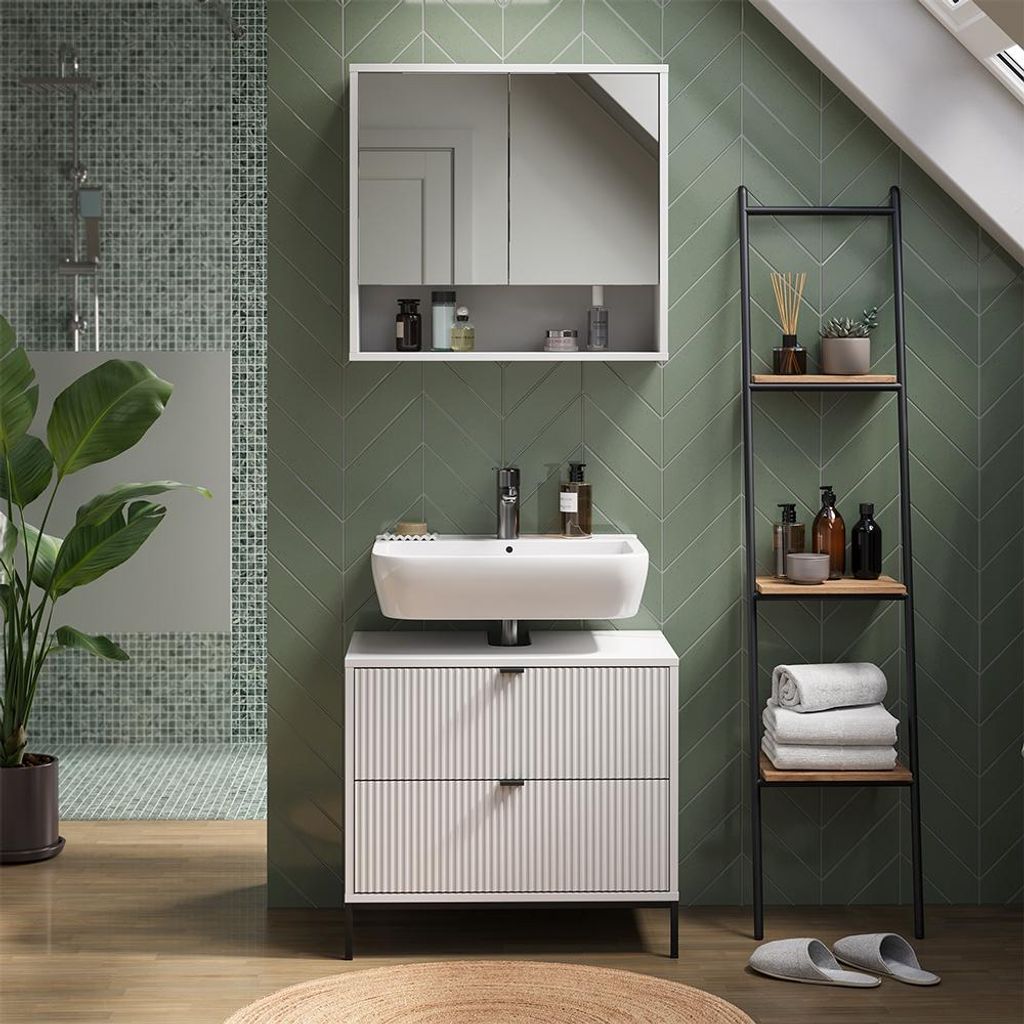 A modern bathroom with a green tiled wall, a white sink and vanity, and a ladder shelf.