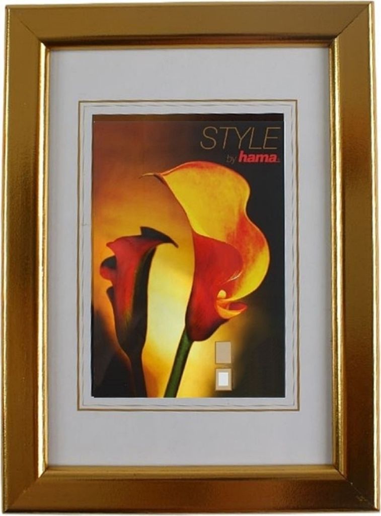 A gold picture frame with a white mat and a picture of calla lilies inside.
