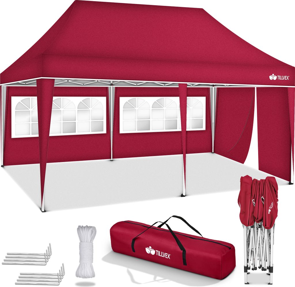 A red pop-up tent with windows and side walls, along with its accessories, laid out on a white surface.