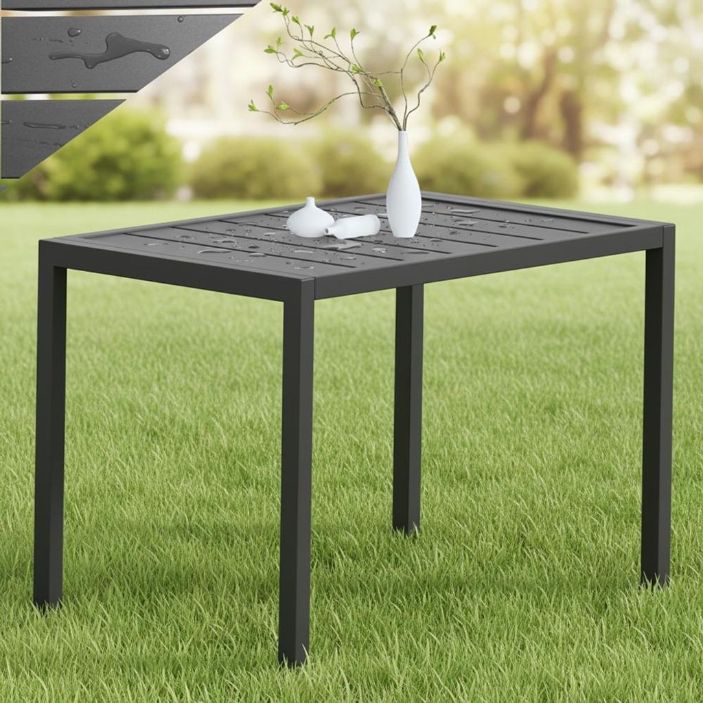 A rectangular outdoor table with water droplets on its surface, placed on a grassy lawn with blurred greenery in the background.