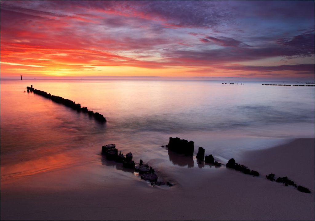 Wallario Poster - Sandstrand im Sonnenuntergang - Roter Himmel, Kunstdruck Größe: 70 x 100 cm