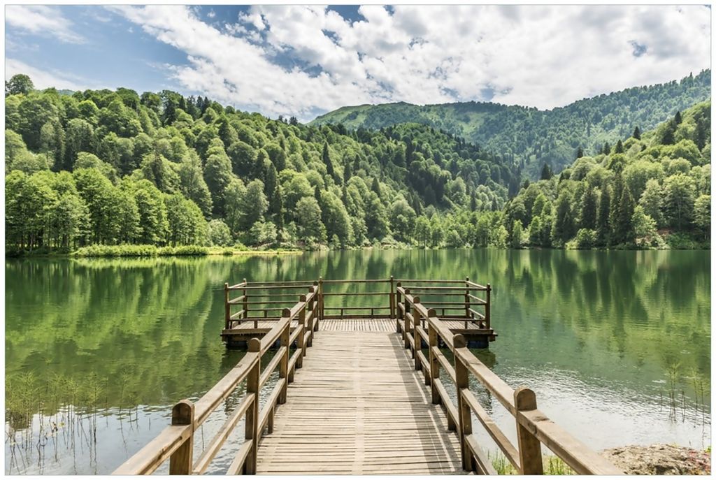 Wallario Premium Glasbild, freischwebende Optik, kräftige Farben, Größe 90 x 60 cm Motiv Steg am See in den Bergen