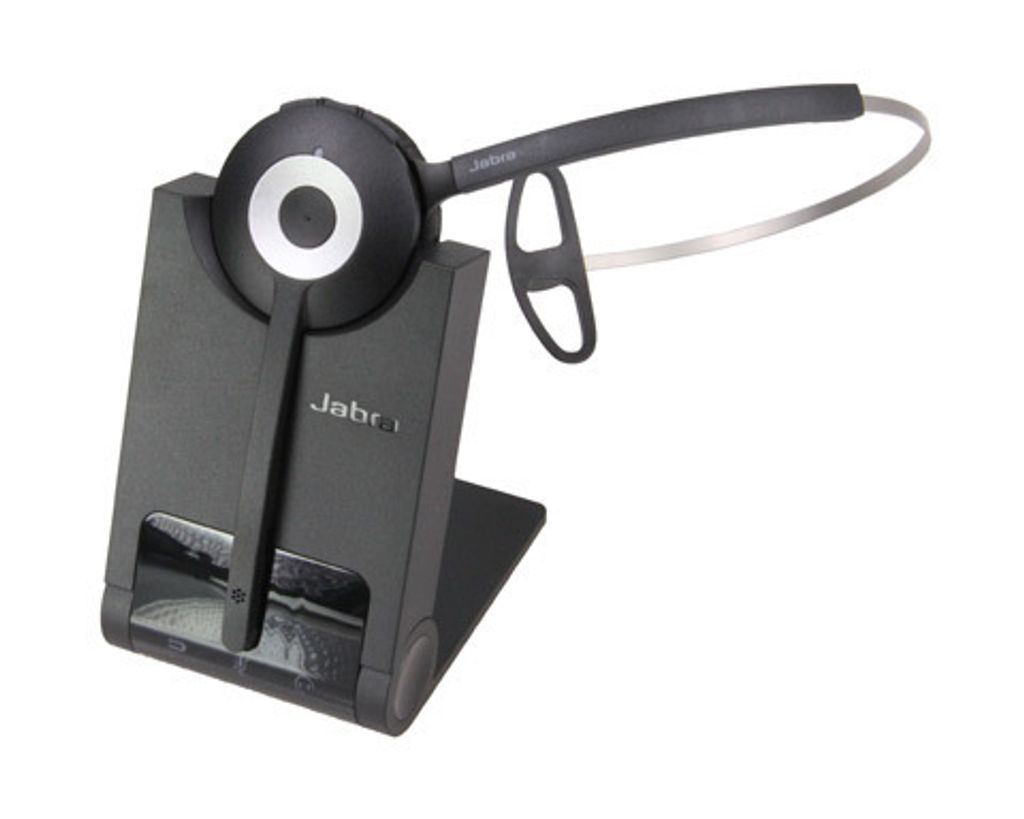 A black Jabra wireless headset is placed on its charging dock.