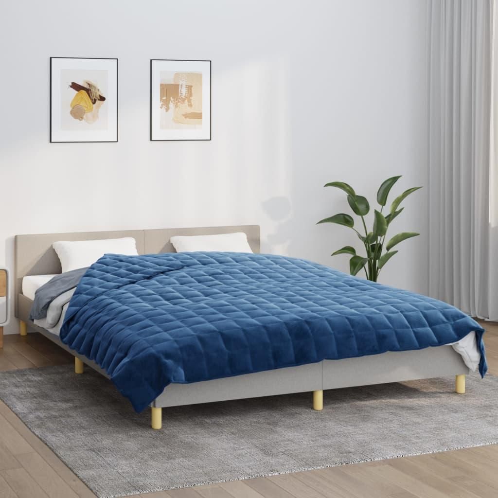 A bedroom scene with a bed covered by a blue blanket.
