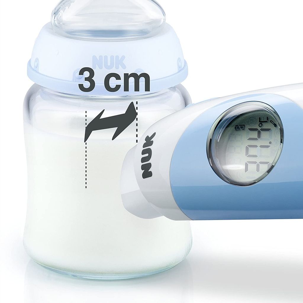 Close-up of a baby bottle with milk and a digital thermometer measuring the temperature. A measurement indicator shows '3 cm'.