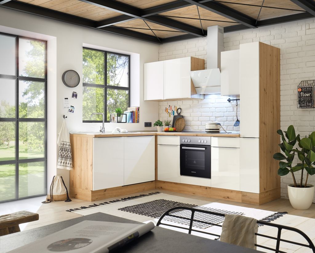 A modern kitchen with white cabinets and wood accents, featuring a large window overlooking a garden.