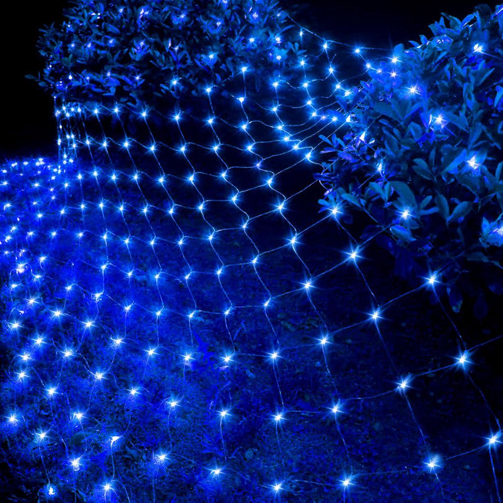 A net of blue lights draped over bushes at night.