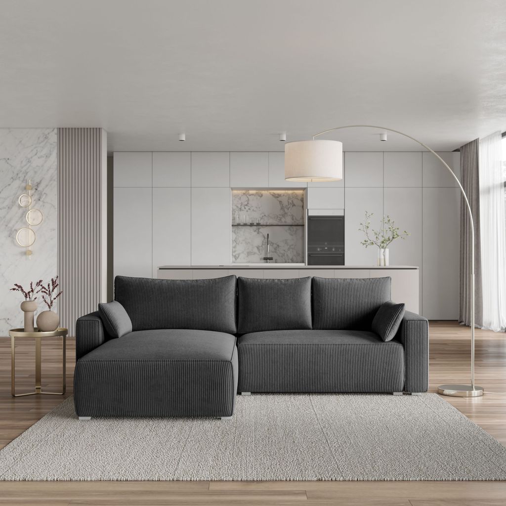 A modern living room with a sectional sofa, kitchen in the background, and a floor lamp.