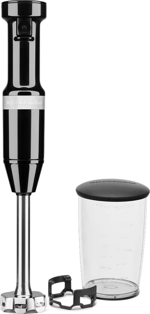 A black KitchenAid immersion blender with its accessories, including a beaker and a blade guard, is displayed against a white background.