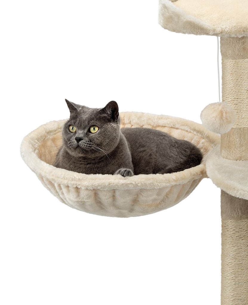 A gray cat is resting in a beige hammock-like bed attached to a cat tree.