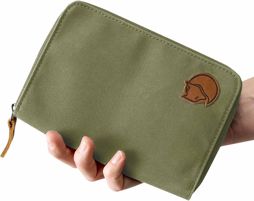A hand holding a green passport wallet.