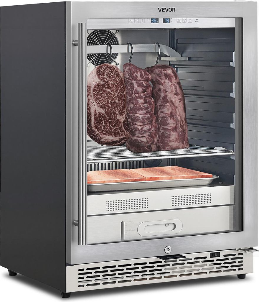 A VEVOR dry-aging refrigerator with three large cuts of beef hanging inside, and a tray of what appears to be salt blocks below.