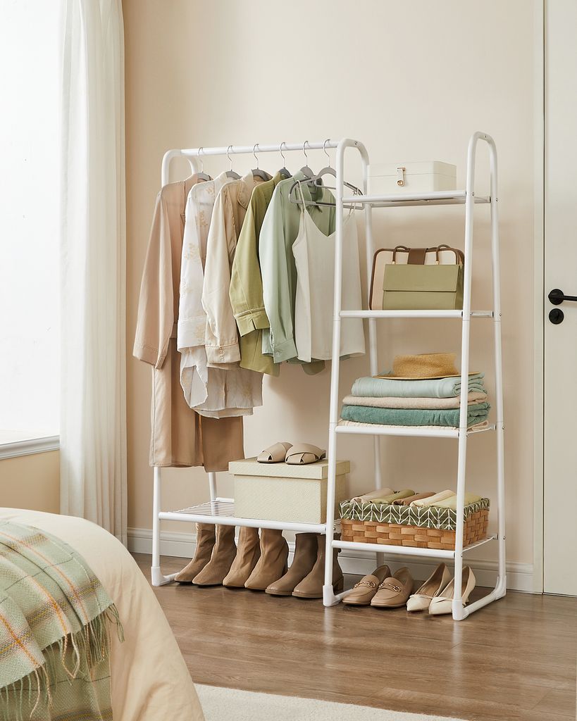 A white clothing rack with clothes and accessories displayed in a room.