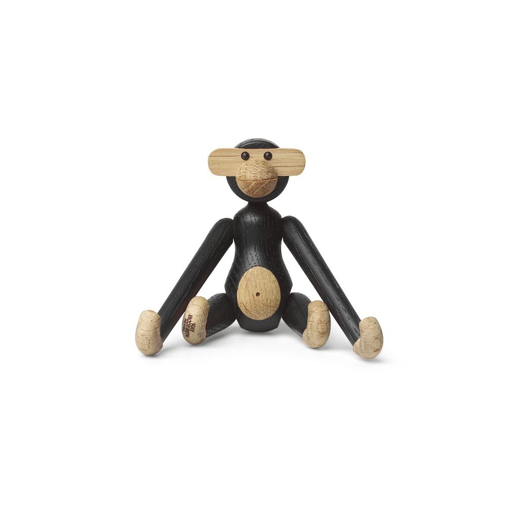 A small wooden monkey toy sitting on a white background.