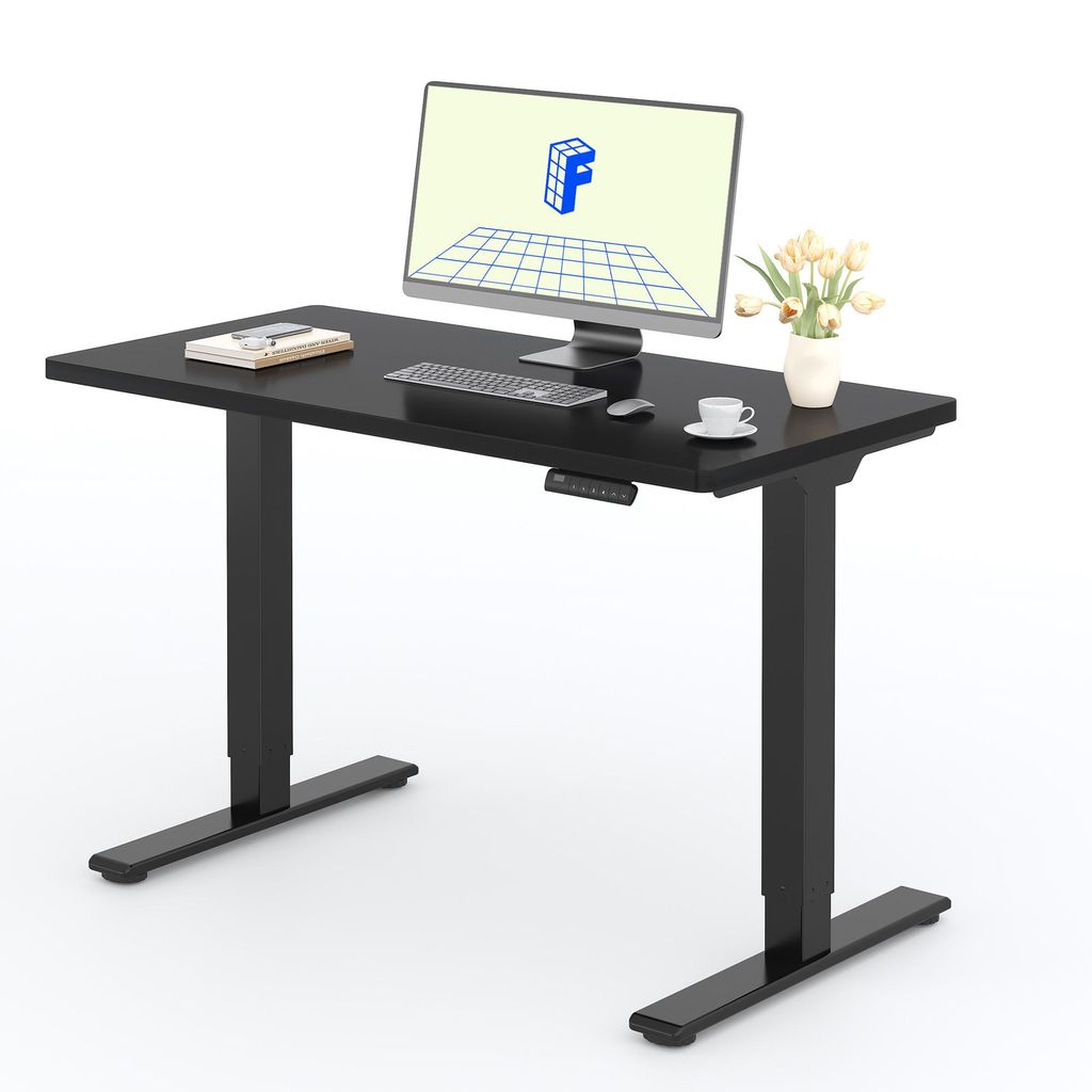 A black adjustable height desk with a computer monitor, keyboard, mouse, and a small vase of flowers.