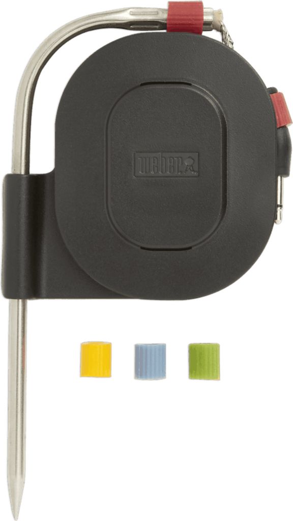 A close-up, top-down view of a meat thermometer with a black casing and silver probe, along with three colored caps.