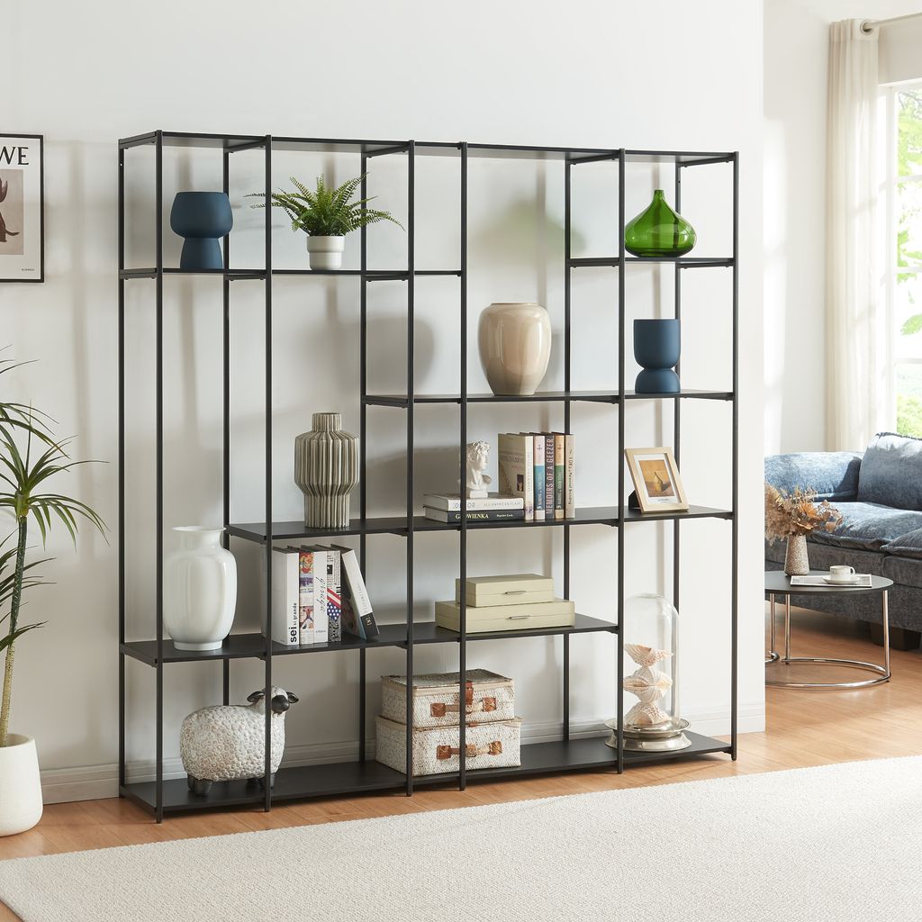 A modern living room with a black metal shelving unit filled with decorative items.