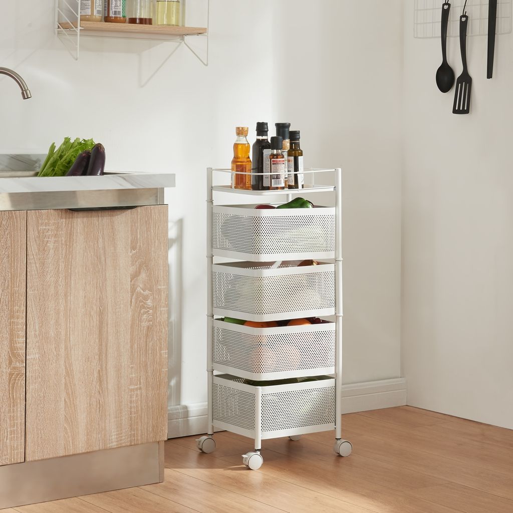 A white rolling cart with four mesh baskets is shown in a kitchen setting next to a wooden cabinet and sink.
