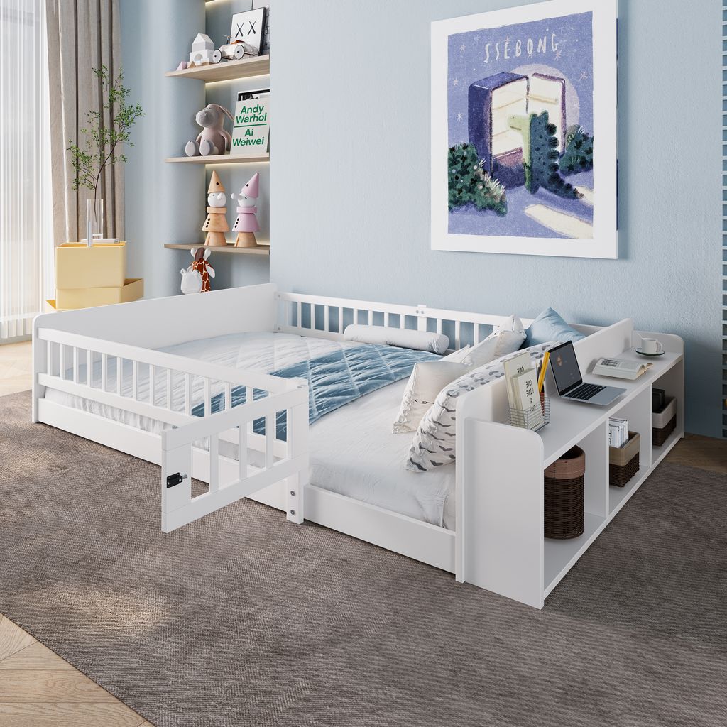 A white wooden children's bed with a built-in shelf unit and a small desk area, set in a child's bedroom with shelves and artwork on the wall.