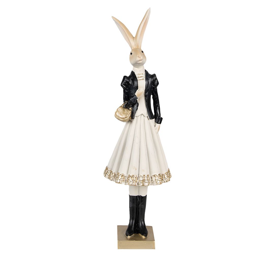 A full-body shot of a decorative rabbit figurine dressed in a black jacket and a white dress, holding a gold purse.