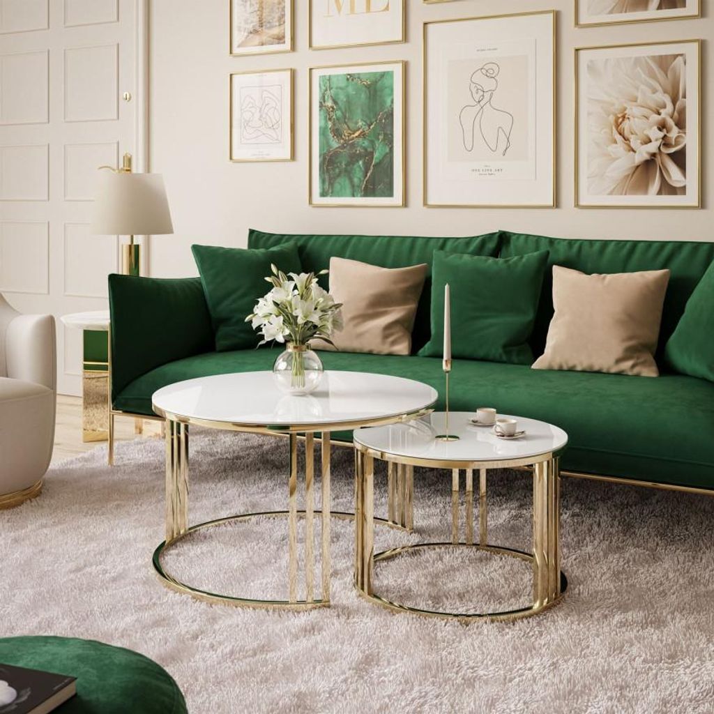 A living room scene with a green sofa, coffee tables, and artwork on the wall.