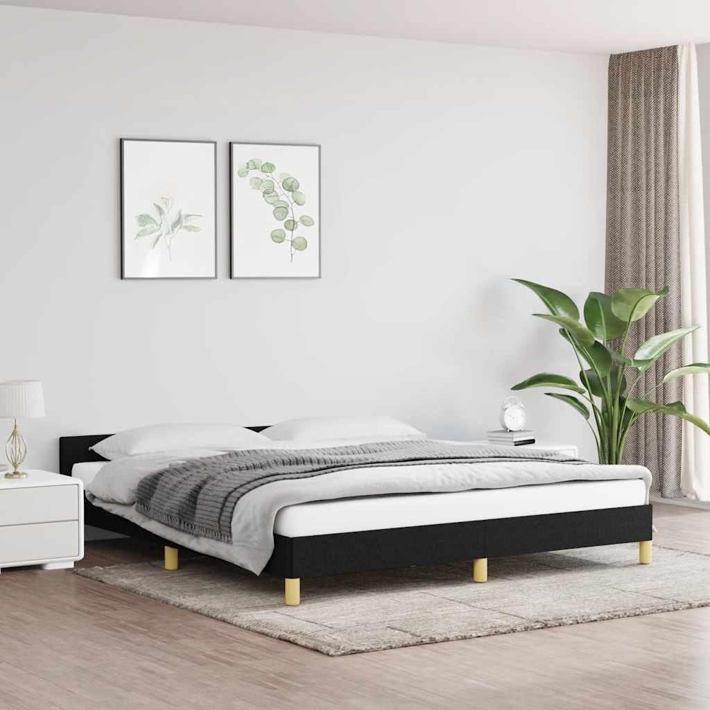 A bedroom scene with a black bed frame and bedding.