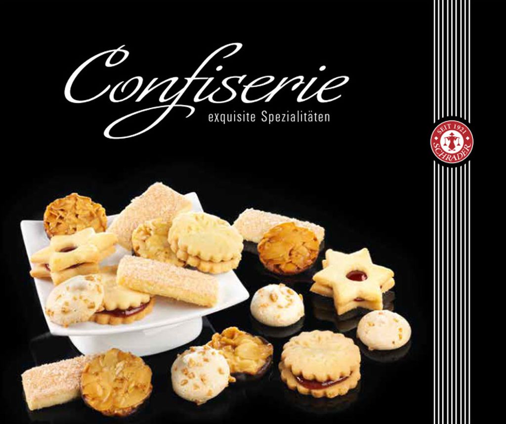 A collection of assorted cookies arranged on a black surface, with a white plate holding some of the cookies.